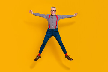 Fototapeta na wymiar Full length photo of good mood energetic grandpa feeling young jumping up isolated on yellow color background