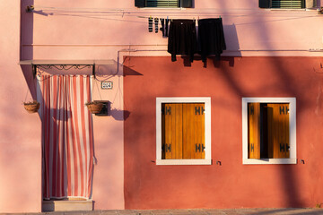 Exterior shot of a traditional pink building with yellow windows in the city of Venice, Italy