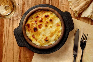 Traditional Georgian baked suluguni in clay ketsi with creamy sauce