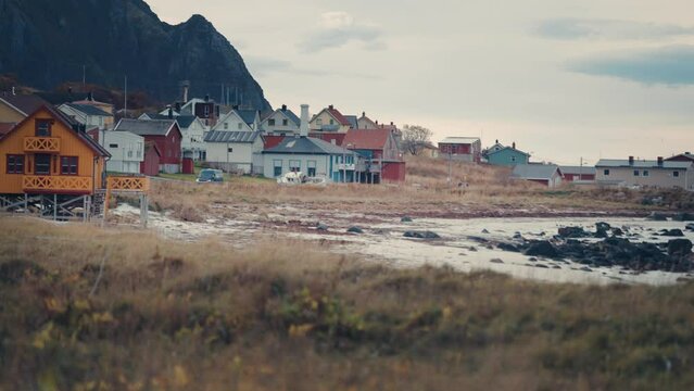 A view of the coastal village of Bleik on the Andoya island, Norway. Tidy houses stand on the shore. It is low tide. Slow-motion, pan left.