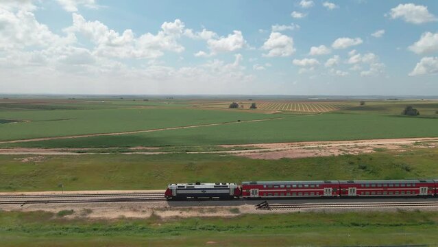 train crosses green fields in cloudy day