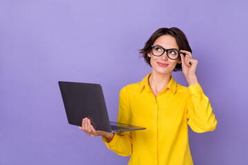 Photo of cute millennial lady hold laptop look up wear yellow outfit eyewear isolated on violet color background