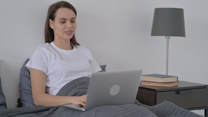 Woman doing Video Call on Laptop in Bed