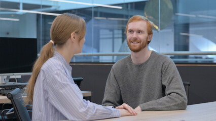 Young Man and Woman having Discussion in Office
