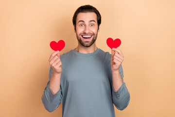 Photo of young excited man hold hands small heart shape romantic cardiac isolated over beige color background