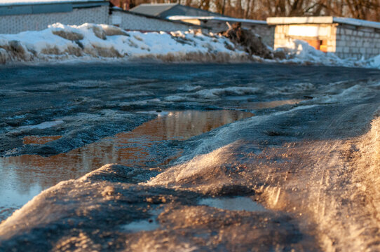 Spring thaw on the road, snow and melting ice