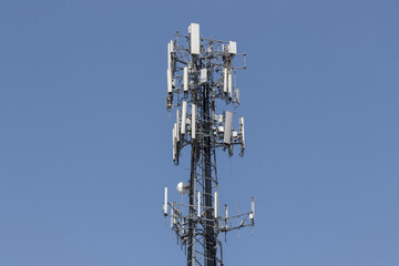 Telecommunications and wireless cell equipment tower with directional mobile phone antenna.