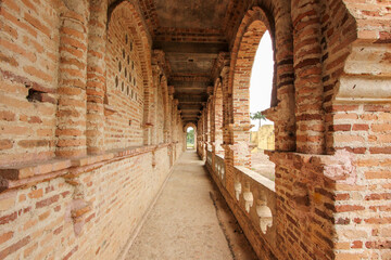 A narrow balcony corridor lined with brick walls in the unfinished monument of Kellie's Castle in Batu Gajah.