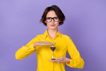 Photo of cute seo young lady hold clock wear yellow outfit eyewear isolated on violet color...