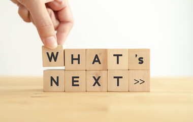 What's next?, business concept. Next step of work, plan, strategies, vision, project implementation, new opportunities and execution.  Putting wooden cubes with What's next?  and forward arrow symbols