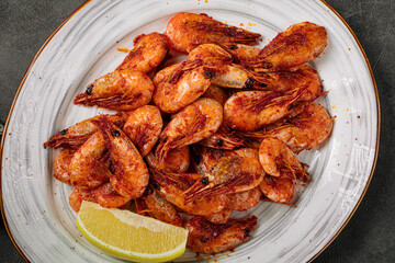 Top view on fried shrimp with lemon in a plate
