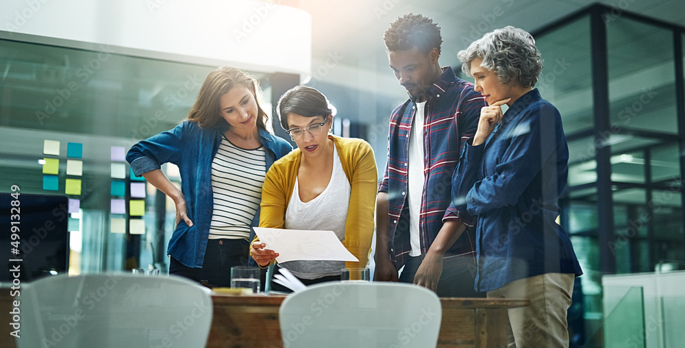 Poster Planning for every eventuality. Shot of a team of creative businesspeople brainstorming in the office.