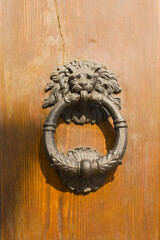 Close view of ancient door knocker on the blue background