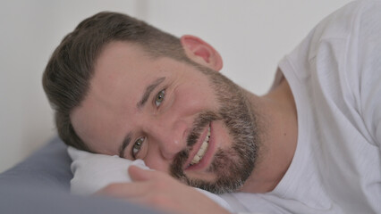 Fototapeta na wymiar Man Talking during Online Video Call while Laying in Bed