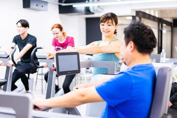 Obraz premium ジムでパーソナルトレーニングを受ける中年男性