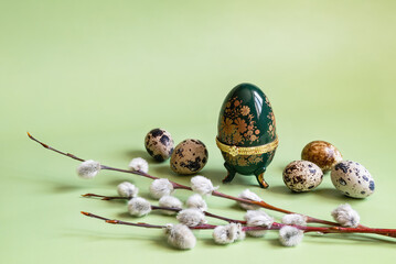 Easter composition. Faberge egg caskets, twigs of pussy willow, and quail eggs on a pale green...