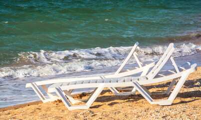Fototapeta na wymiar Beach chairs on the beach with waves