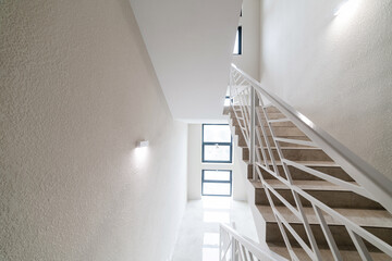 interior photo of the corridor with stairs and white metal railings
