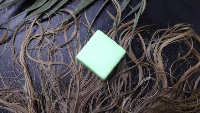 Solid hair shampoo. Composition of golden curls, soap suds, solid shampoo and comb. The concept of female care for long hair.