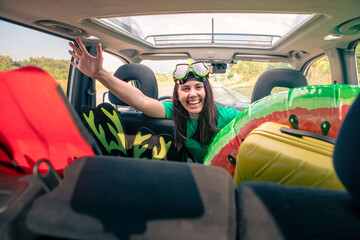 sea car travel trip smiling woman driver in car full of vacation stuff