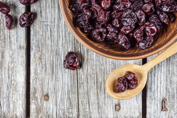 Dried cherries in a clay plate on a wooden table in a rustic style