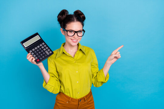 Photo of positive lady hold calculator indicate finger empty space isolated on blue color background