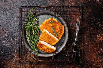 Cordon bleu chicken fillet cutlet with ham and cheese. Dark background. Top view - obrazy, fototapety, plakaty