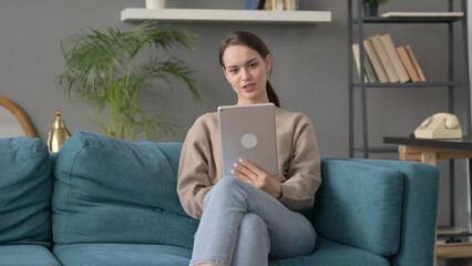 Woman Talking on Video Call on Tablet on Sofa 