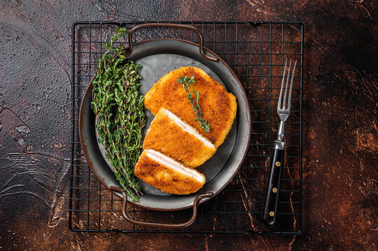 Cordon bleu chicken fillet cutlet with ham and cheese. Dark background. Top view