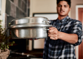 Serving up a feast. Closeup shot of an unrecognisable man holding a pot used for barbecued meat.