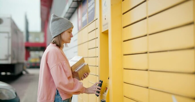 Woman Skans QR Code on Mobile Smartphone to Send Parcel with Self-service Locker Cell with Bar code Reader. Modern Shipping and Delivery Concept with Contactless Automated Postal Box. 6K handheld shot