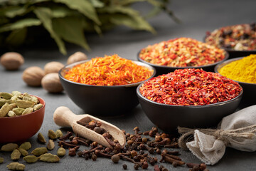 Bowls of various aromatic spices and herbs. Different seasoning - red hot pepper, paprika, anise,...