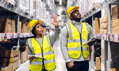 Portrait two african american engineer team shipping order detail on tablet check goods and supplies on shelves with goods inventory in factory warehouse.logistic industry and business export