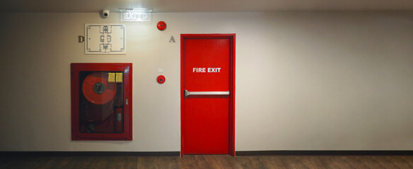 Fire exit door. Fire exit emergency door red color metal material with alarm and emergency light and fire extinguish equipment on building wall for safety protection. Doors for escape conflagration. - obrazy, fototapety, plakaty