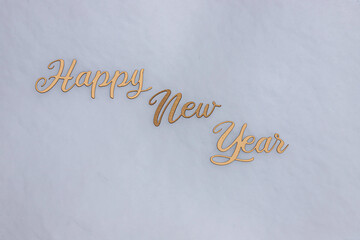 celebration concept inscription in gold letters on the snow, Happy New Year text on pastel background