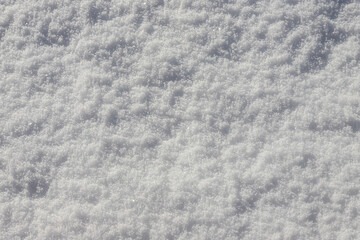 Beautiful winter background with snowy ground. Natural snow texture. Wind sculpted patterns on snow surface