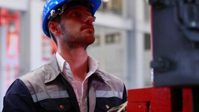 lathe and stamping metal machine. Hispanic man and Factory engineer in hard hat helmet working on digital teblet computer at Heavy Industry Manufacturing Factory.