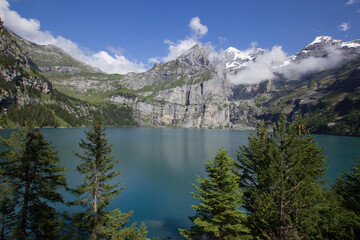 Lake Oeschinen (Oeschinensee) in the bernese Oberland (Switzerland) seen from the shore with moutains in the background