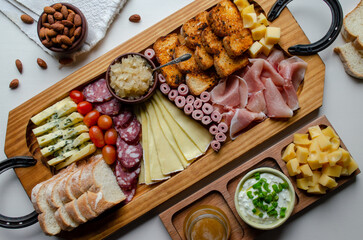 Delicious Charcuterie Board with snacks cheese, toast, ham, blue cheese, almonds, caramelized onions, green onion, honey, toast. Flat-lay view. Family, friends holiday.