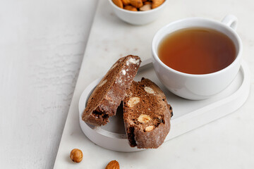 Italian chocolated cantucci with almond and hazelnuts. Biscotti cookies with nuts and cup of tea. Homemade biscotti. White background