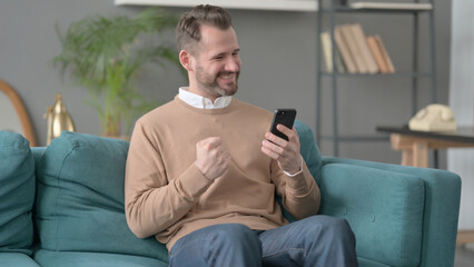 Man having Success on Smartphone at home