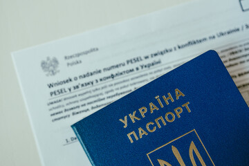 PESEL document, Ukrainian passport and a pen on white table background.