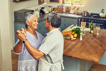 Nothing inspires romance like food. Shot of a happy mature couple dancing together while cooking in the kitchen at home.