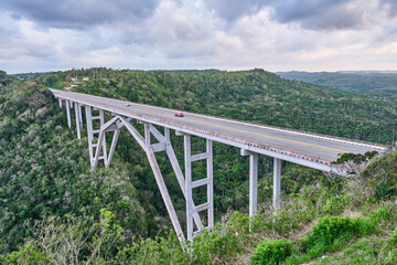 Fototapeta na wymiar The highest of Cuba Bacunayagua Bridge. Automobile transport moving along bridge.