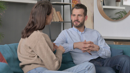 Serious Man Talking to Woman While Sitting on Sofa 