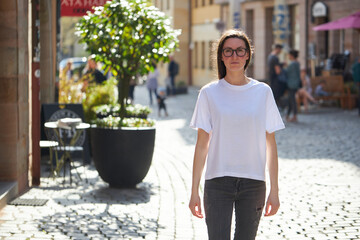 Woman in white blank t-shirt wearing glasses in the city