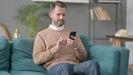 Man using Smartphone on Sofa 