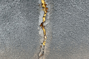 Crack in the cement wall. The crack in the gray wall is sealed with construction foam