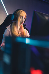 Fototapeta premium Beautiful young adult woman playing a computer game, vertical. High quality photo