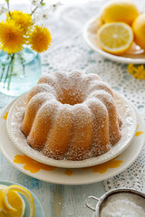 Lemon bundt cake (Babka) sprinkled with powdered sugar served on a plate, close up view